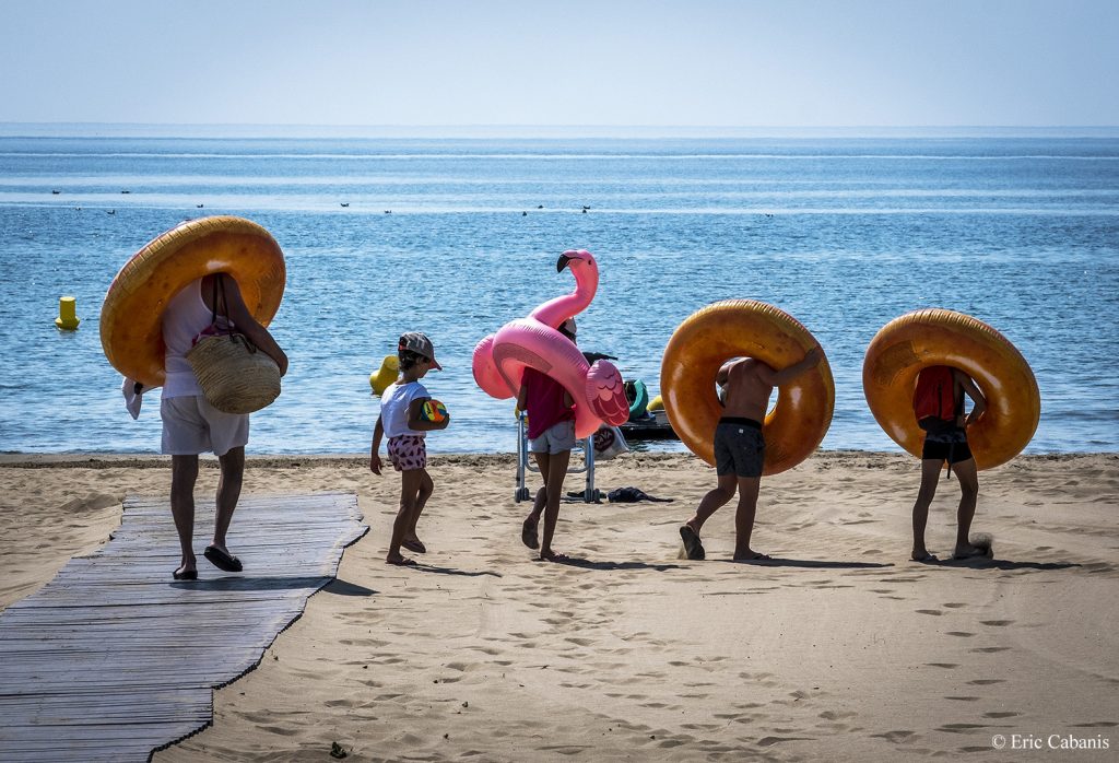 Une famille se rend à la plage avec des bouées géantes en juillet 2019 à Narbonne-Plage A family goes to the beach with giant buoys in July 2019 at Narbonne-Plage Photojournalism Streetphotogtraphy Eric Cabanis