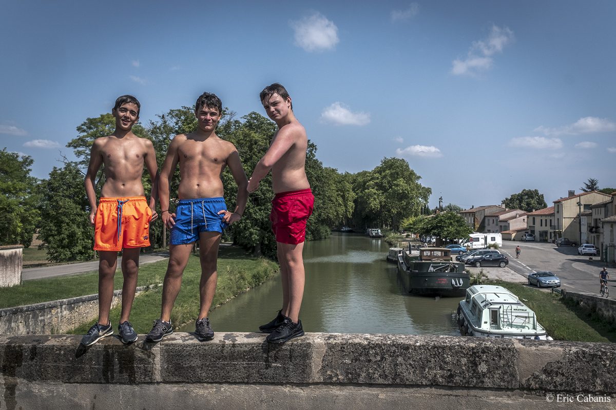 Trois jeunes plongeurs posent sur le parapet du pont qui enjambe le Canal du Midi au Ségala dans l'Aude en juillet 2017 Three young divers pose on the parapet of the bridge over the Canal du Midi at the small port of Ségala in the Aude in July 2017