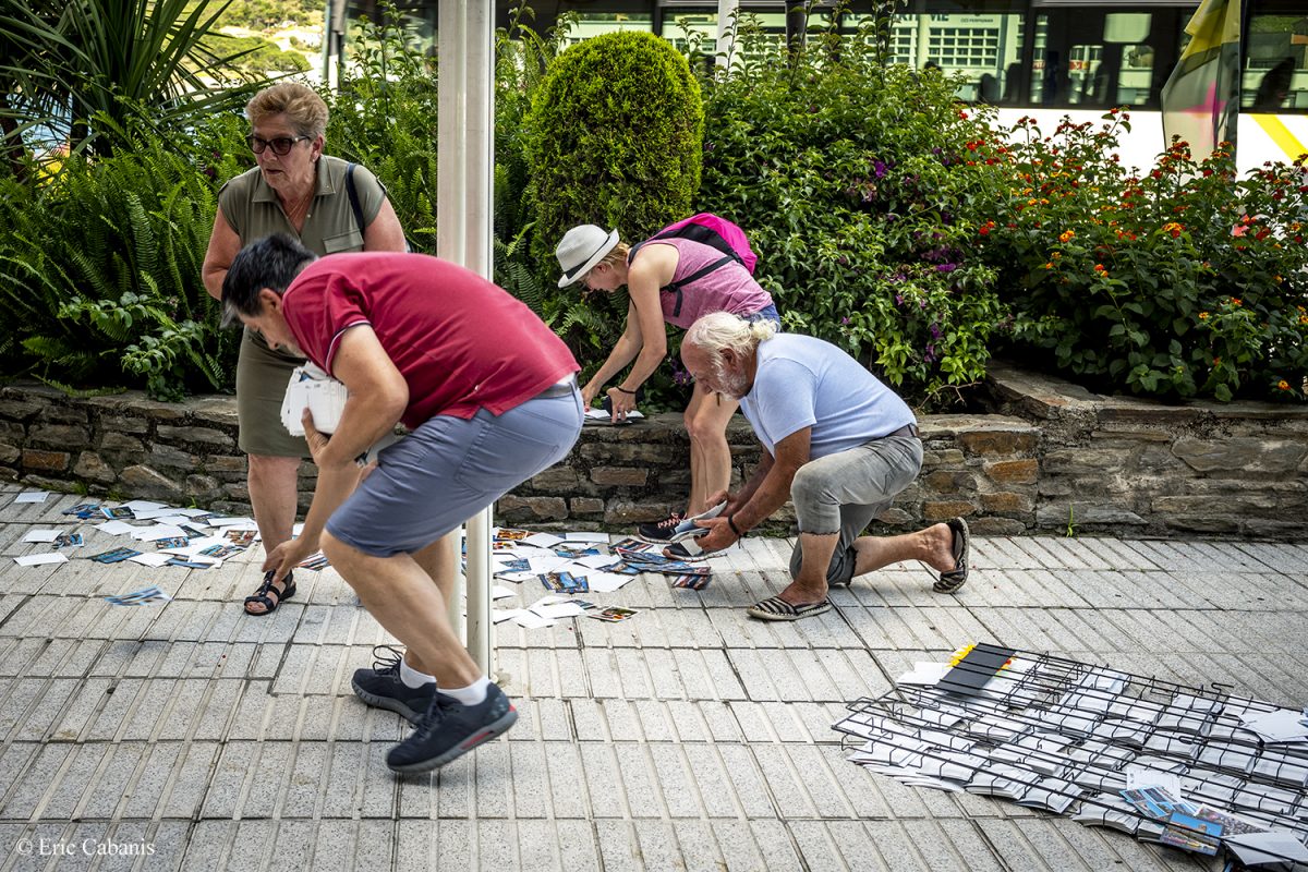 Des personnes ramassent des cartes postales après un coup de vent qui a fait tomber le présentoir le 26 juin 2020 devant une boutique Eric Cabanis Photojournaliste